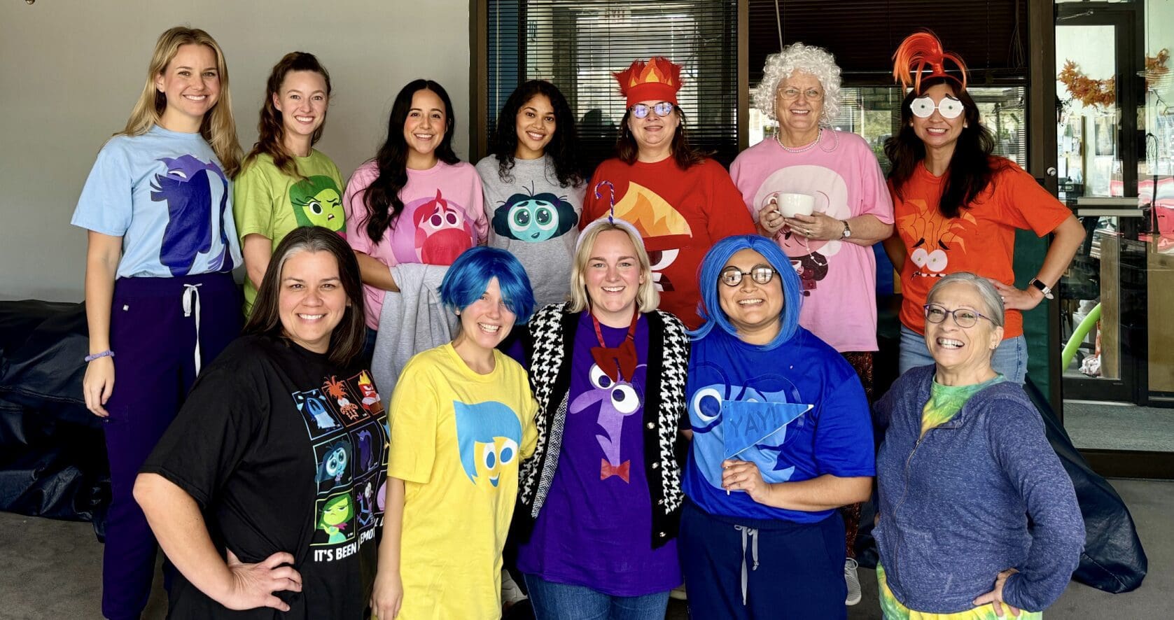 A group of people dressed in colorful wigs and matching shirts